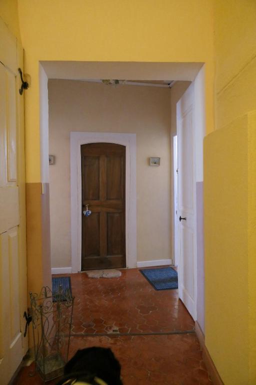een lege hal met een houten deur in een kamer bij la métairie de Martine in Riez