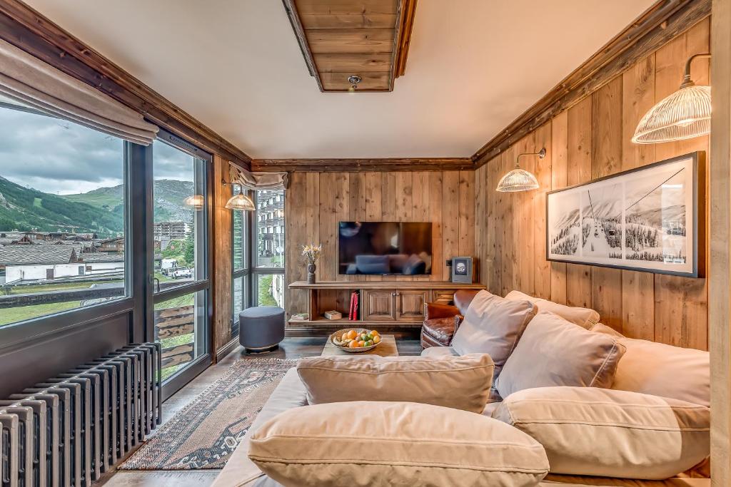 a living room with wooden walls and a large window at HOTEL LE VAL D&#39;ISERE in Val-d&#39;Isère