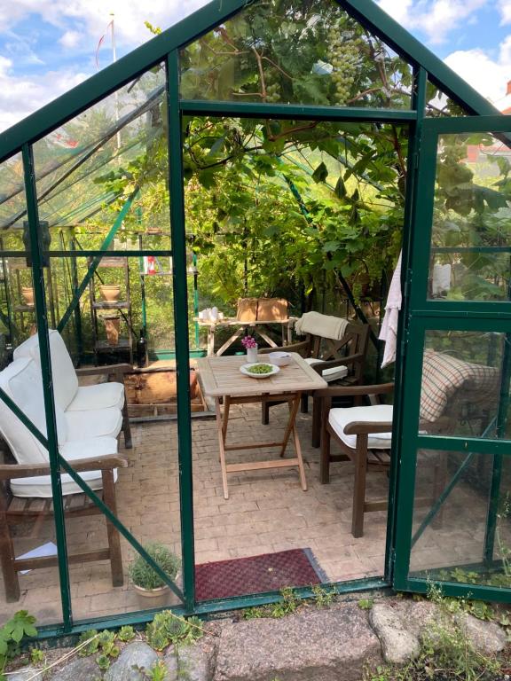 a greenhouse with a table and chairs in a yard at City House in Odense