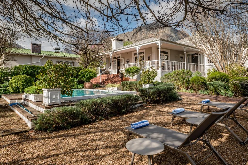 a house with a pool and chairs in front of it at Corner House Residence in Franschhoek