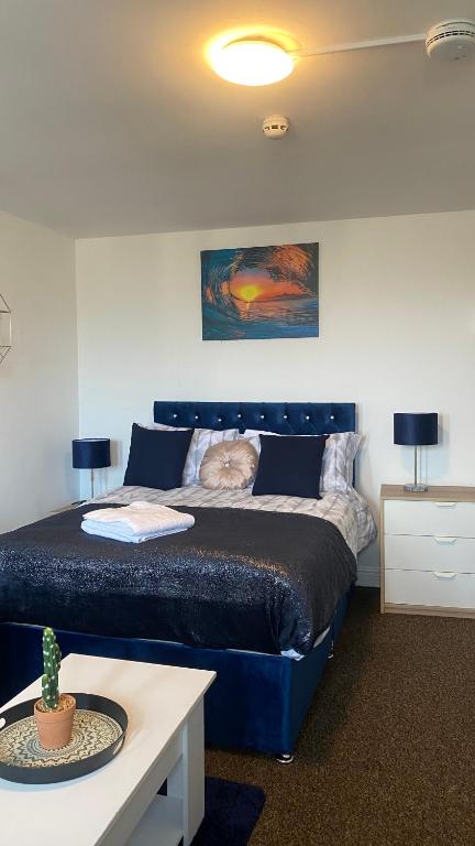 Un dormitorio con una cama azul con un gato. en Bv Cosy Studio Eleven At Deighton Huddersfield, en Huddersfield
