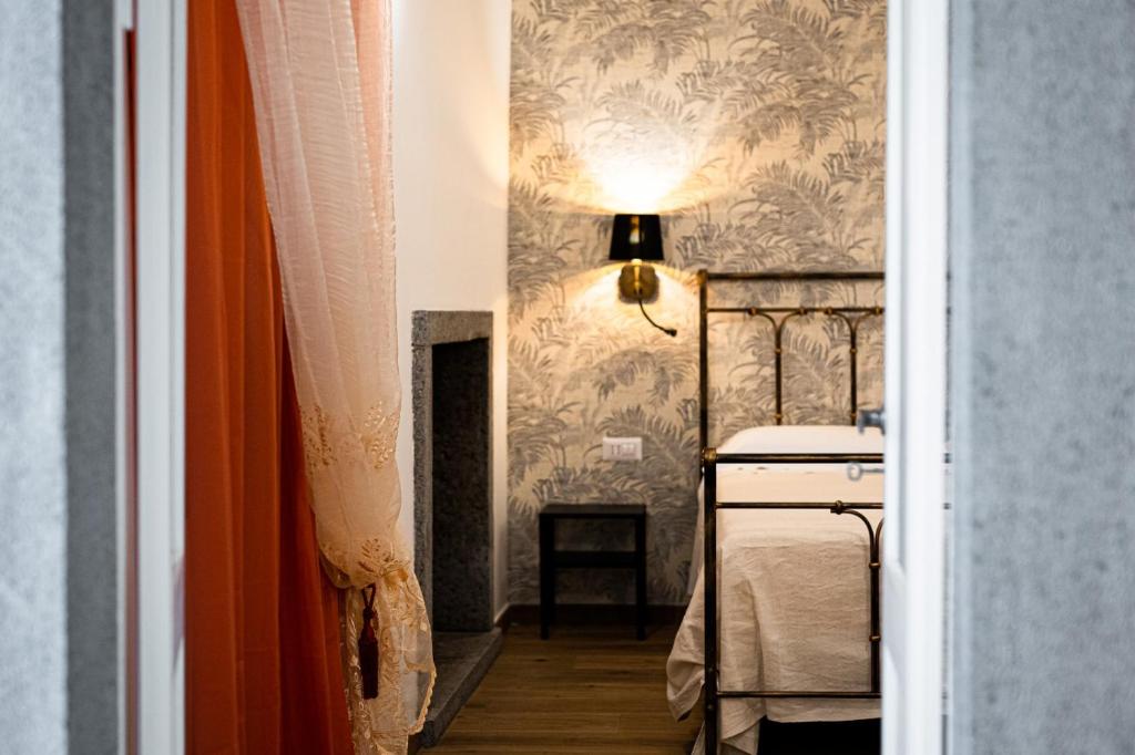 una camera con letto e lampada a muro di La Dimora del Principe a Bagnoregio