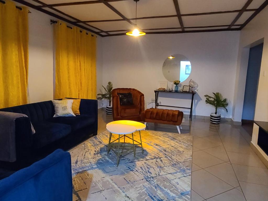 ein Wohnzimmer mit einem Sofa und einem Tisch in der Unterkunft The Nest Airbnb - Milimani, Kitale in Kitale