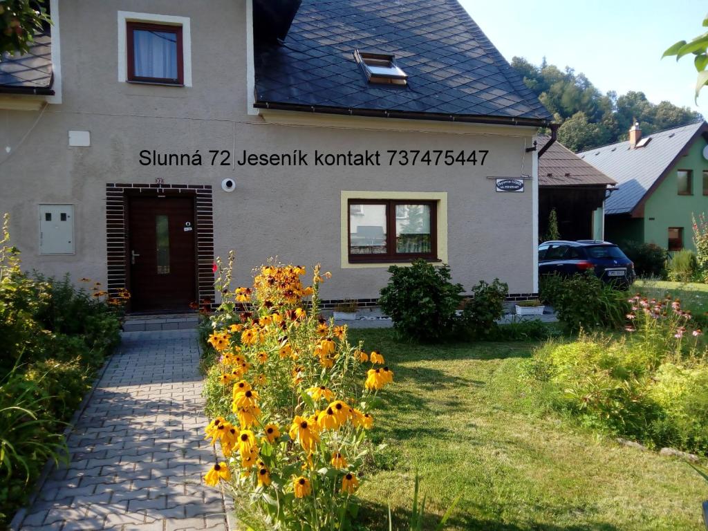 Ein Haus mit einem Haufen Blumen davor in der Unterkunft Ubytování Lumik in Jeseník