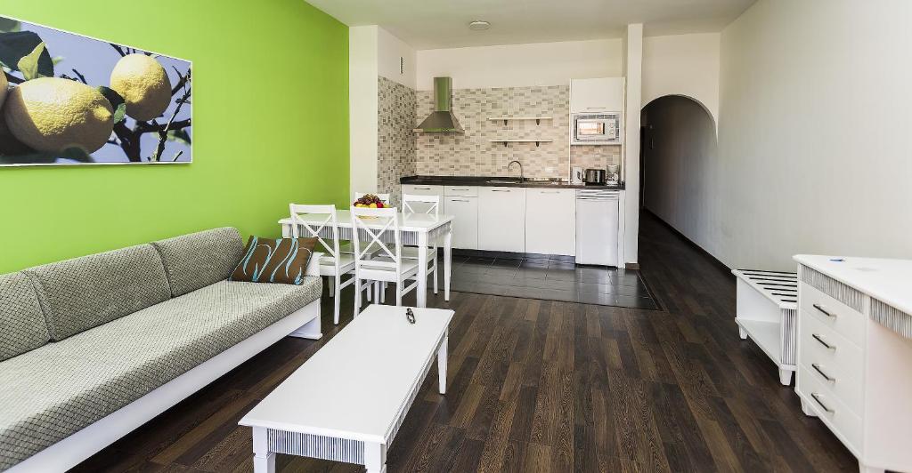 a living room with a couch and a table and a kitchen at Coral Los Alisios in Los Cristianos