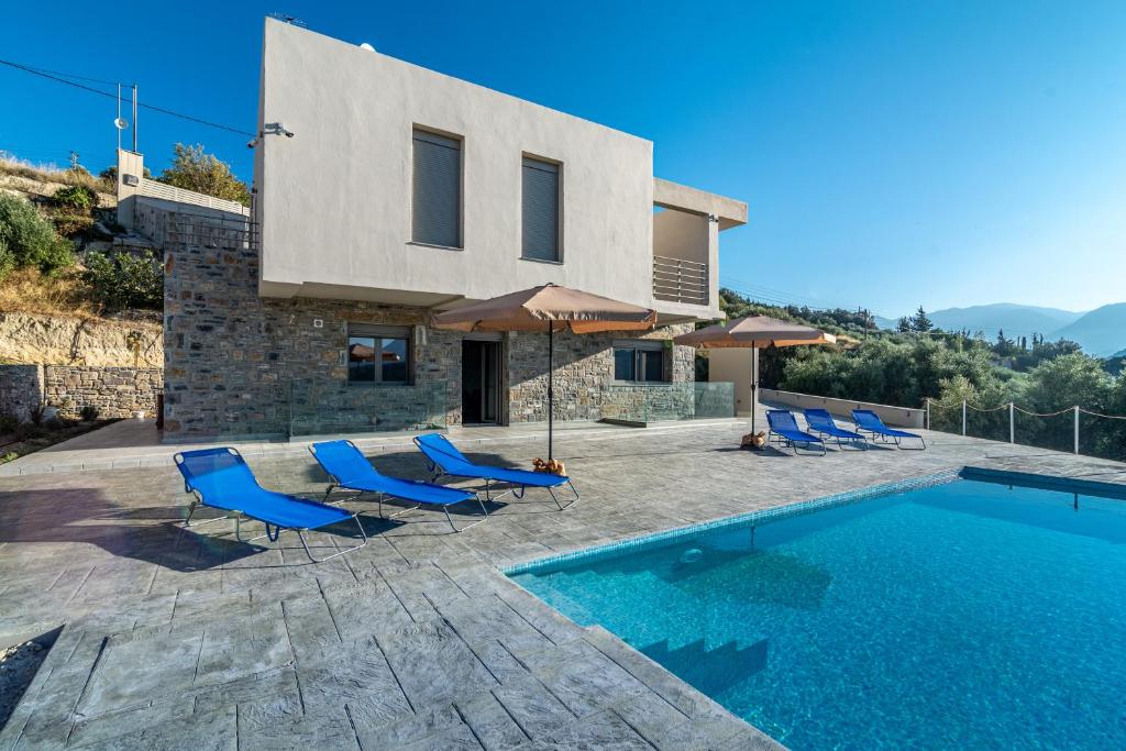 Willa z basenem i niebieskimi krzesłami w obiekcie Candia Panorama Villa w Heraklionie