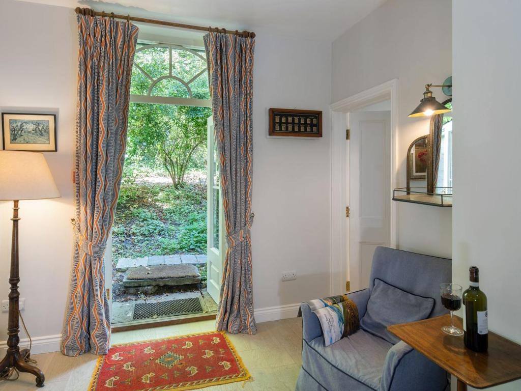 a living room with a blue couch and a window at The Nook At Henge Estate in Shrewton