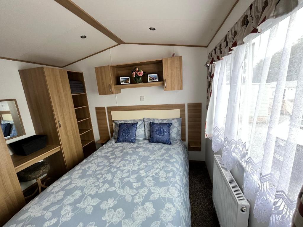a small bedroom with a bed in a rv at JS Holidays Tebay Lagganhouse in Ballantrae