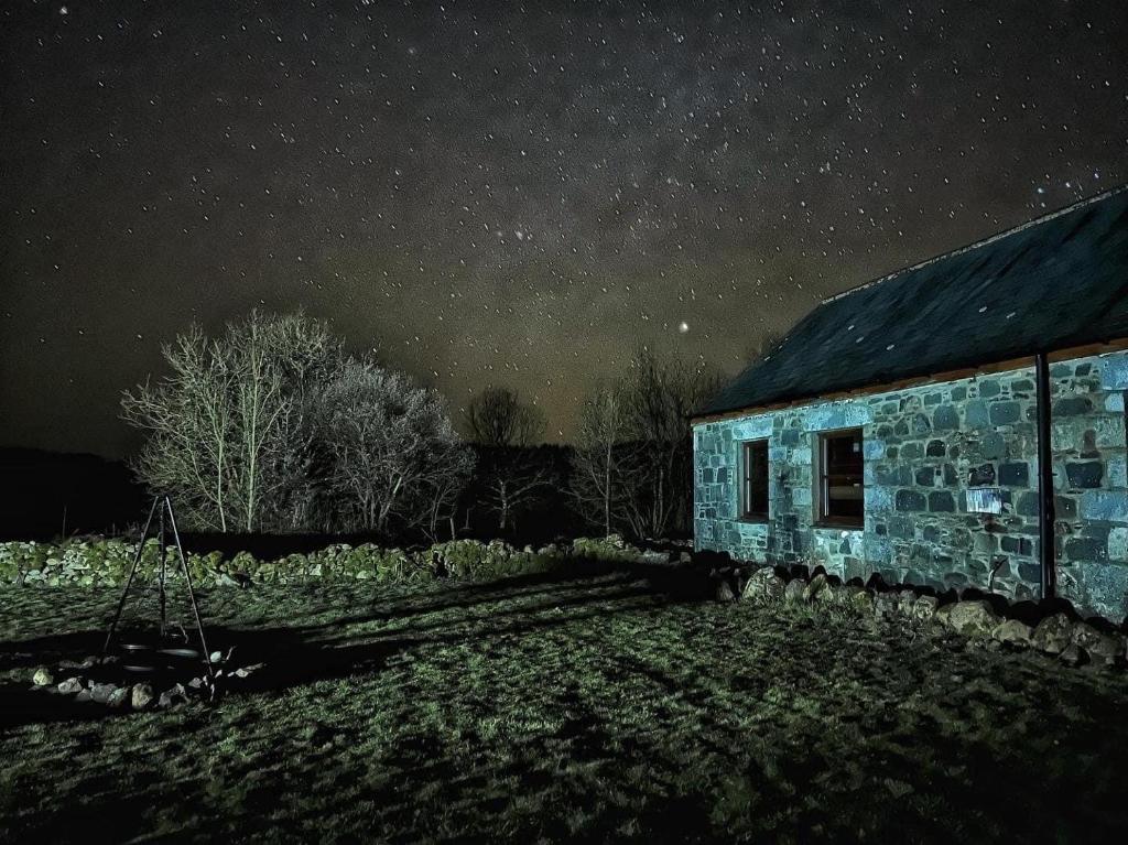 een stenen gebouw onder een sterrenhemel 's nachts bij Anne's Cottage in Bargrennan
