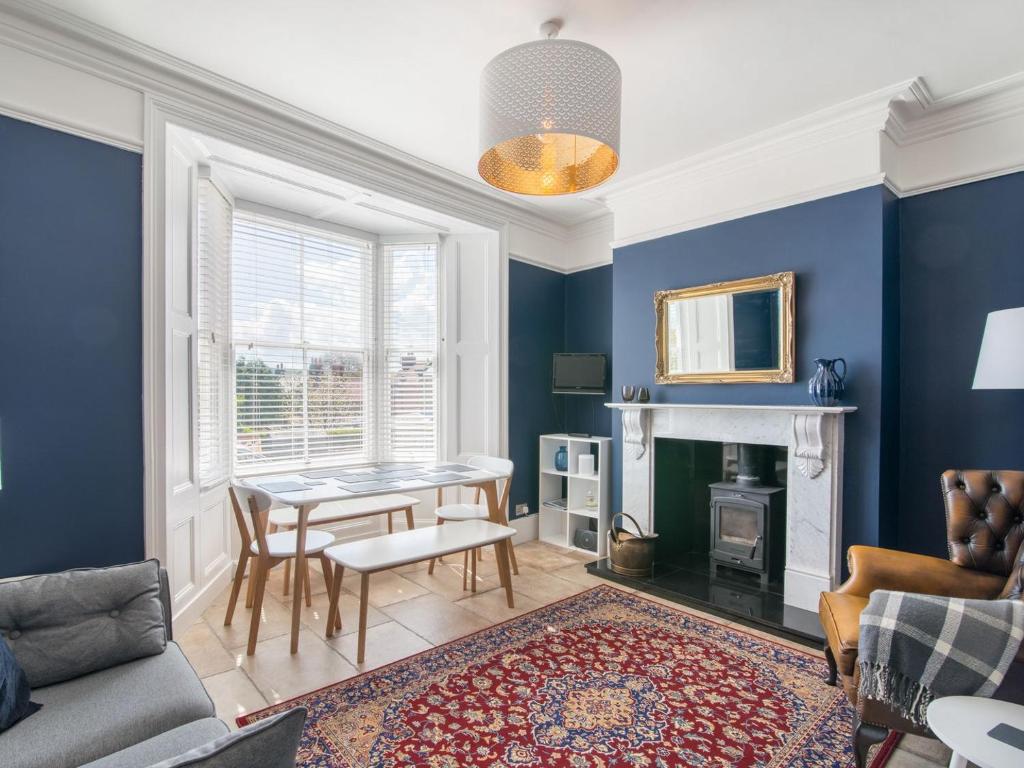 a living room with blue walls and a table at Edenholme in Robin Hood's Bay