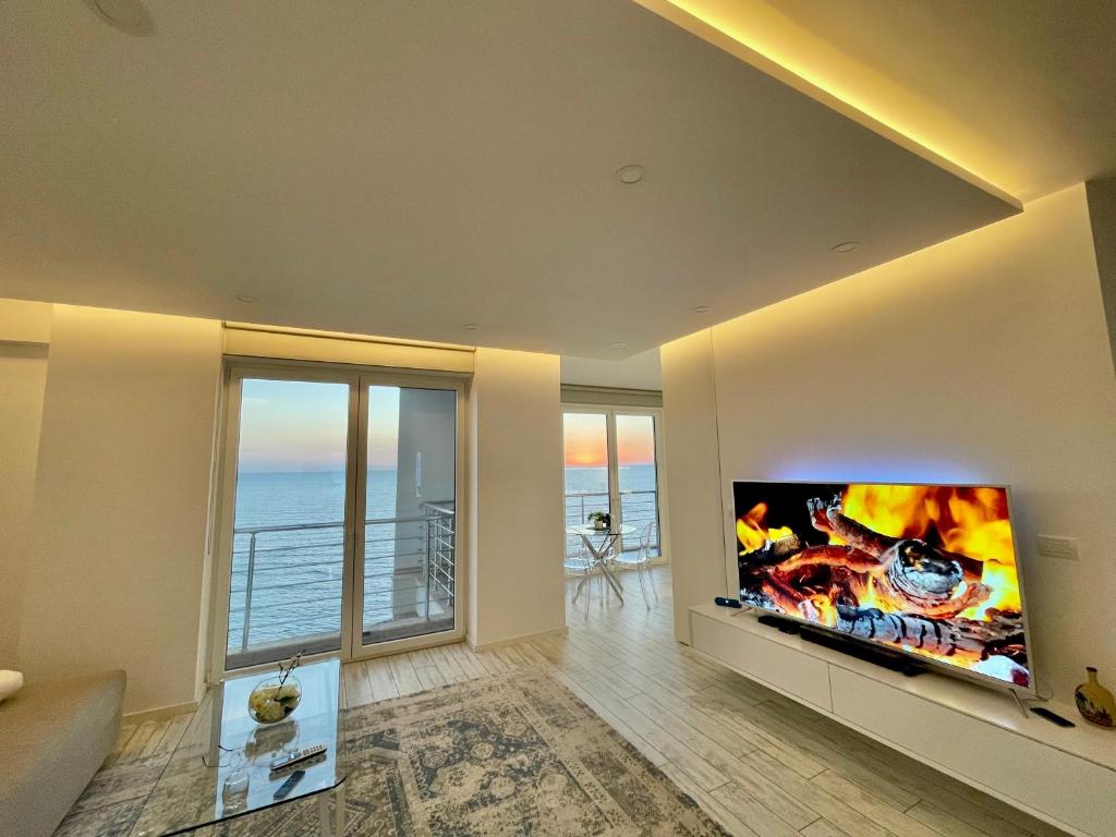 un salon avec une grande télévision murale à écran plat dans l'établissement Durres Currila Modern Luxury STUNNING Beach Views, à Durrës