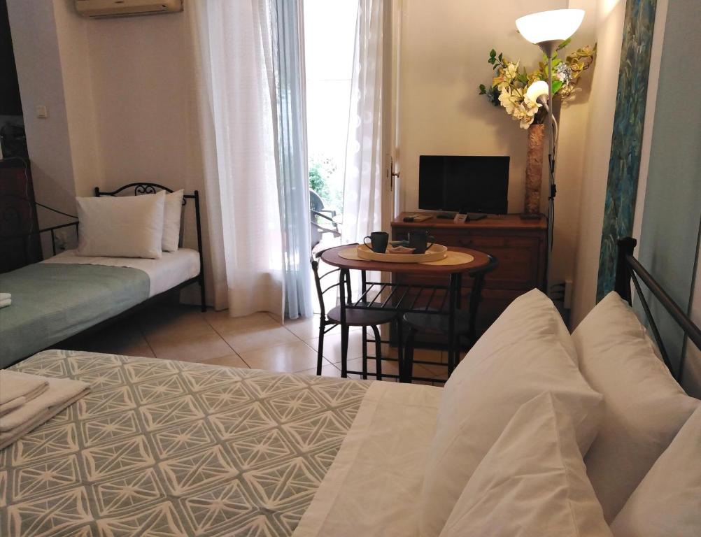 um quarto com uma cama e uma mesa com uma televisão em La casa di Maria em Atenas