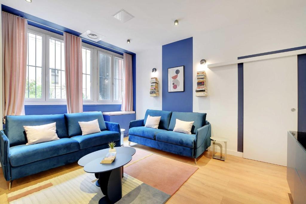 un salon avec deux canapés bleus et une table dans l'établissement Modern apartment - 1BR-6P - AC - Marais, à Paris