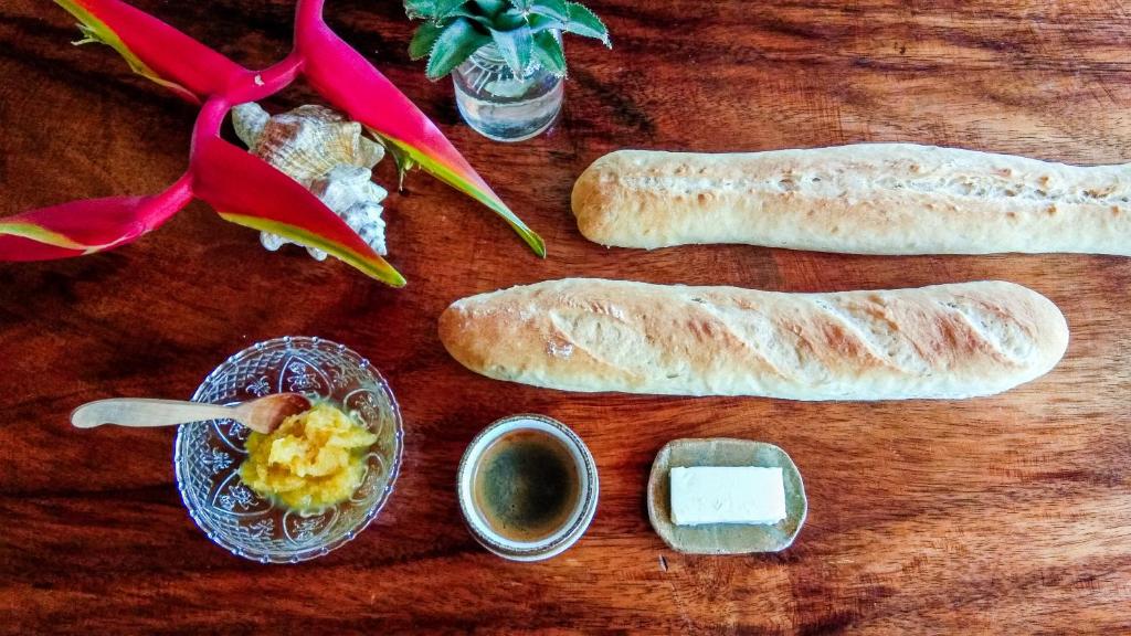 a wooden table with bread and other ingredients on it at Café des Arts Gili Air in Gili Islands