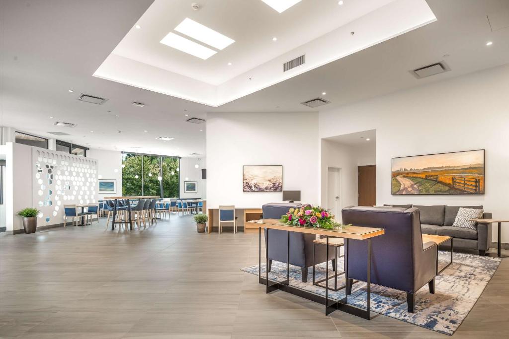 een lobby met een wachtkamer met stoelen en een tafel bij Coast Tsawwassen Inn in Delta