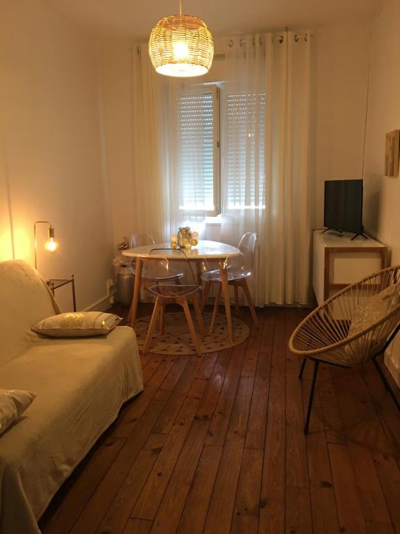 a living room with a table and a table and chairs at Esprit Cosy in Alençon