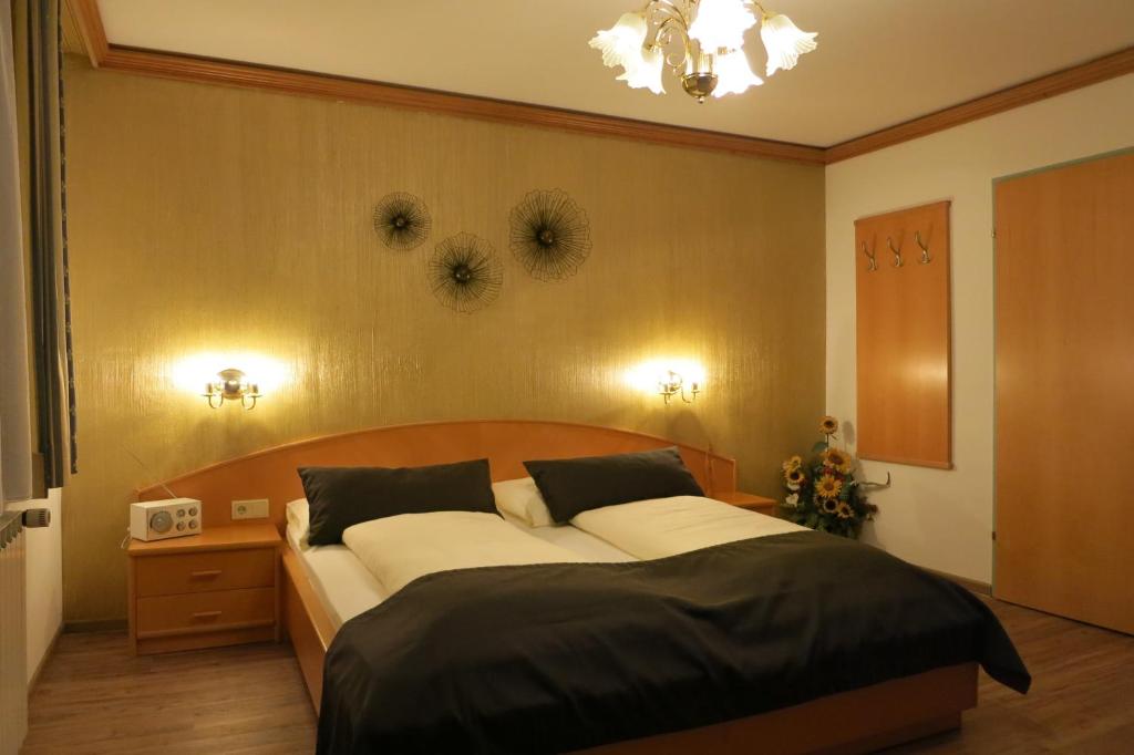 a bedroom with a large bed and a clock on the wall at Haus Wiesenrain in Radstadt