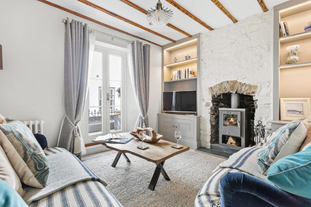 a living room with a couch and a fireplace at 1 Quayside in Appledore