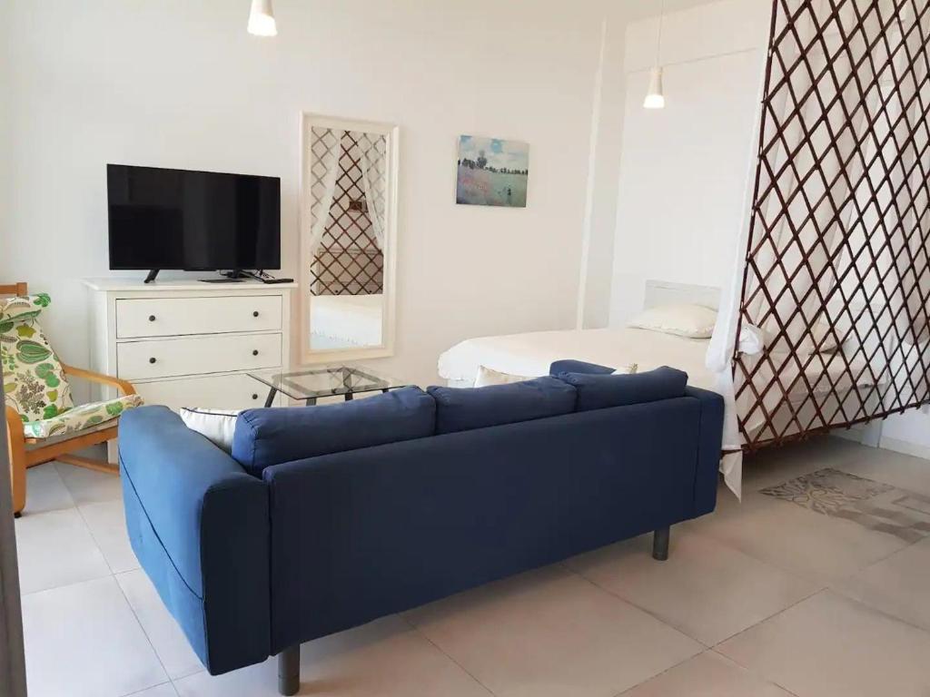 a living room with a blue couch and a bed at Seaview Modern Studio in Sihanoukville