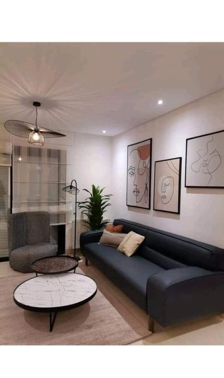 a living room with a blue couch and a table at Superbe Appartement kantaoui sousse in Sousse