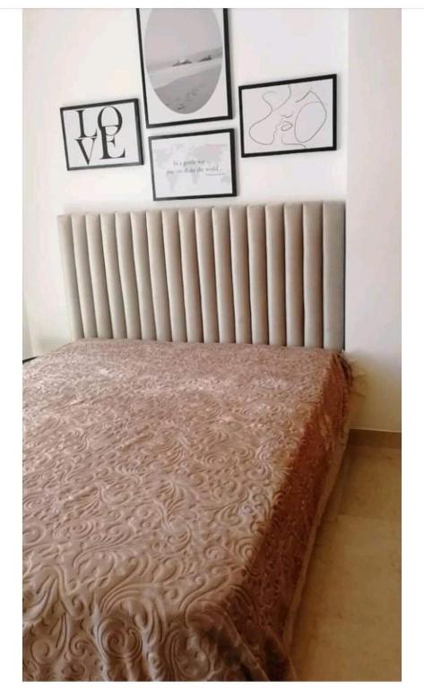 a bedroom with a radiator and some pictures on the wall at Superbe Appartement kantaoui sousse in Sousse
