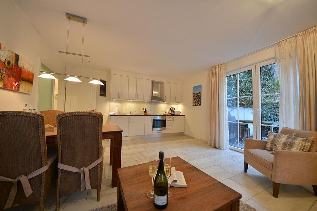 a living room with a dining table and a kitchen at Villa Verdi - Ferienwohnung 2 in Wangerooge