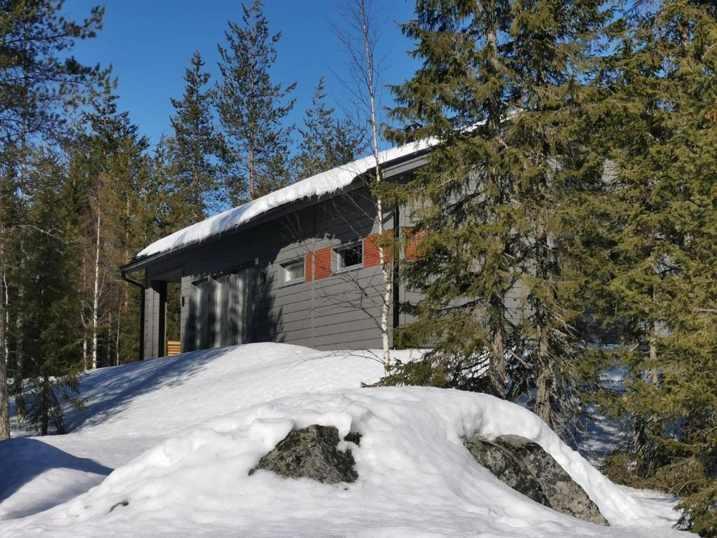 une maison avec un tas de neige devant elle dans l'établissement Metsän Ukko, à Syöte
