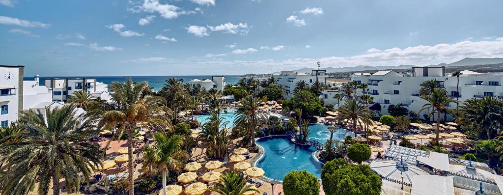 einen Luftblick auf ein Resort mit einem Pool in der Unterkunft Seaside Los Jameos in Puerto del Carmen