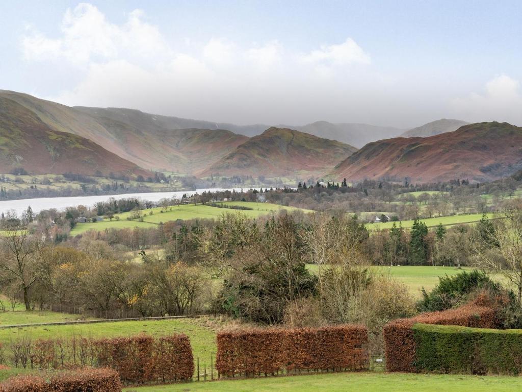 uma vista para um vale com montanhas ao fundo em Mell Fell em Watermillock