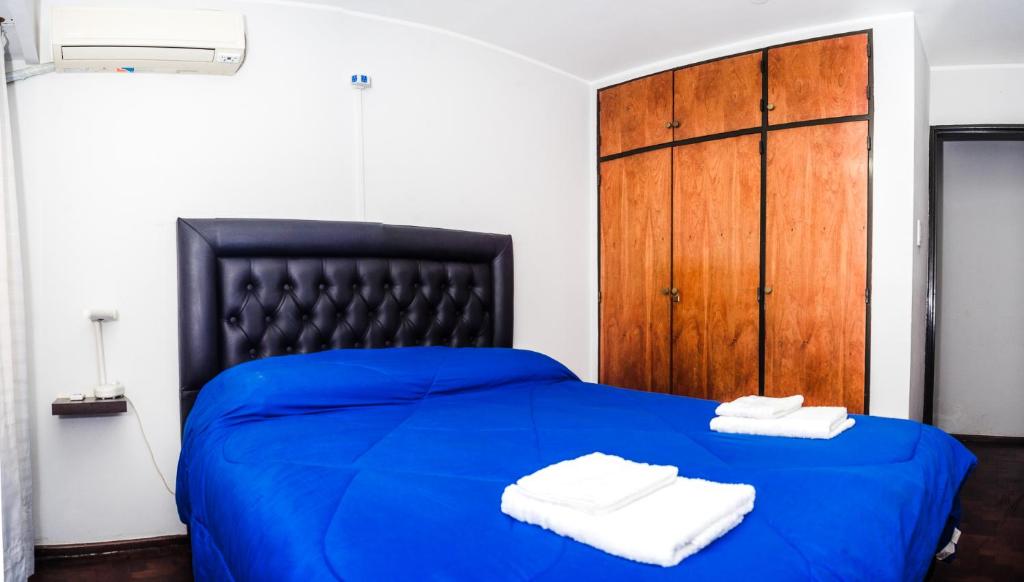 uma cama azul com duas toalhas em cima em Departamento increíble en Cordoba em Córdoba