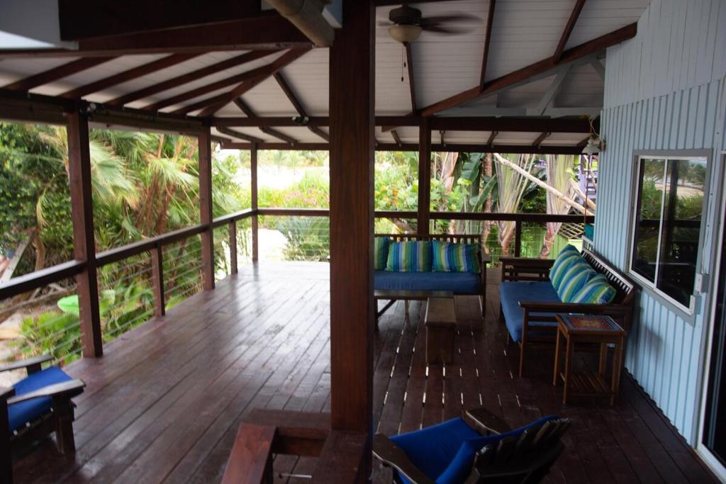 a porch with blue chairs and a wooden floor at Seagrape Escape in Maya Beach