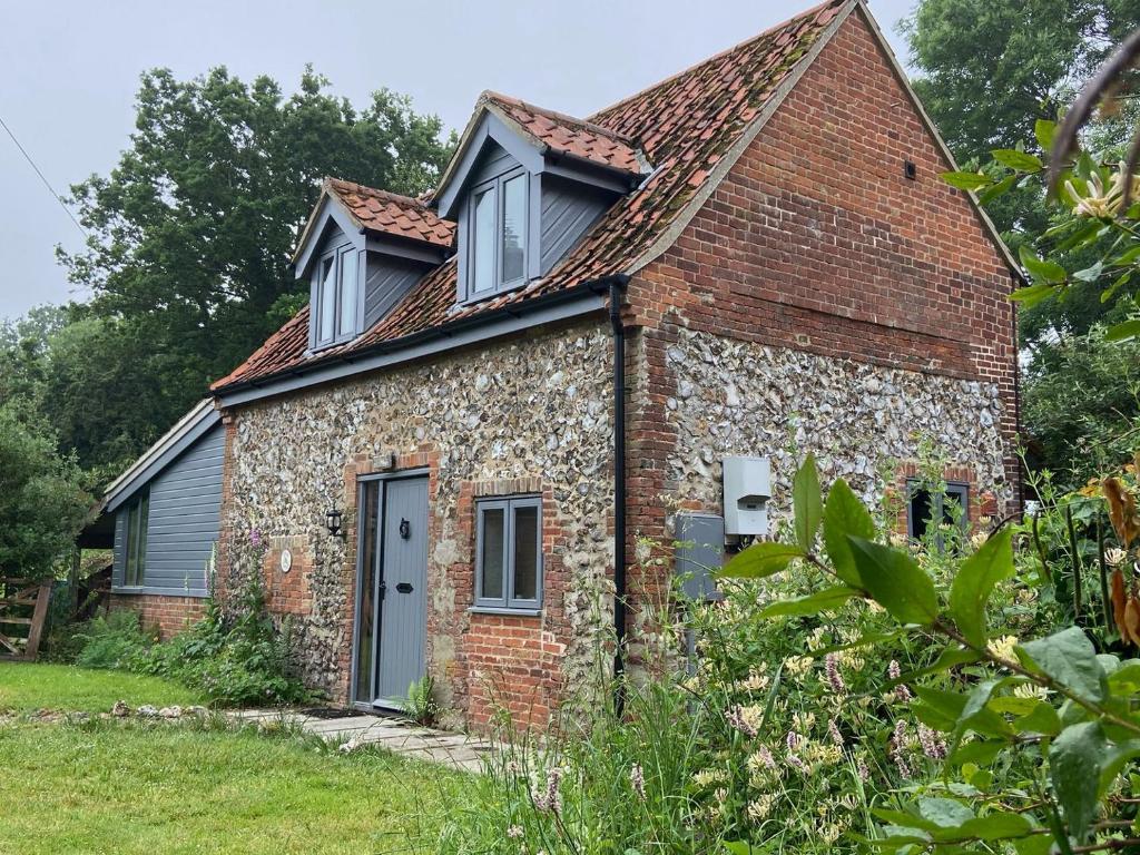 an old brick cottage with a pitched roof at Eden Cottage in Little Hautbois