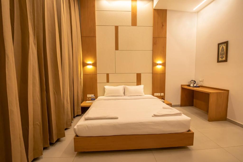 ein Schlafzimmer mit einem Bett in einem Zimmer in der Unterkunft RATHNA RESIDENCY - Near US CONSULATE in Chennai