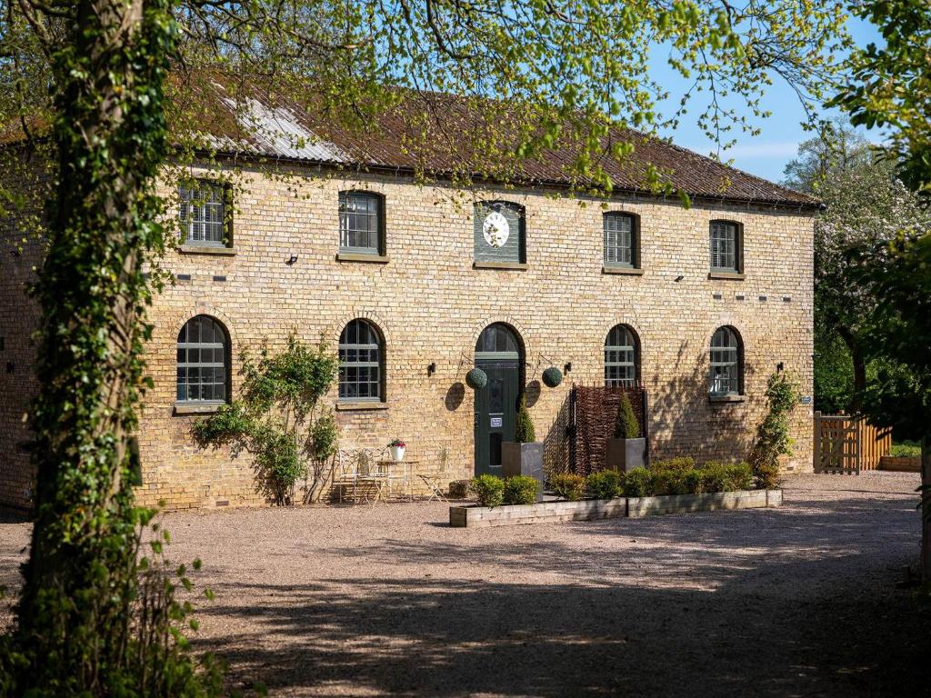 a brick building with a clock on the front of it at Boot Room in Benniworth