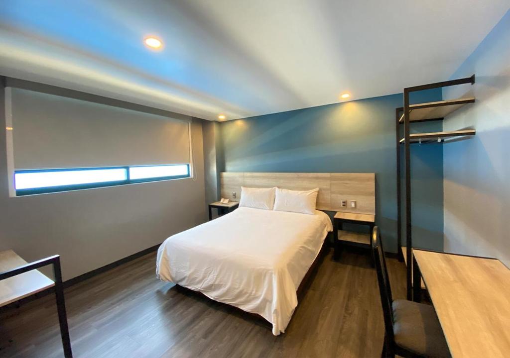メキシコシティにあるHotel Estrella de Orienteのベッドルーム(白いベッド1台、二段ベッド1組付)