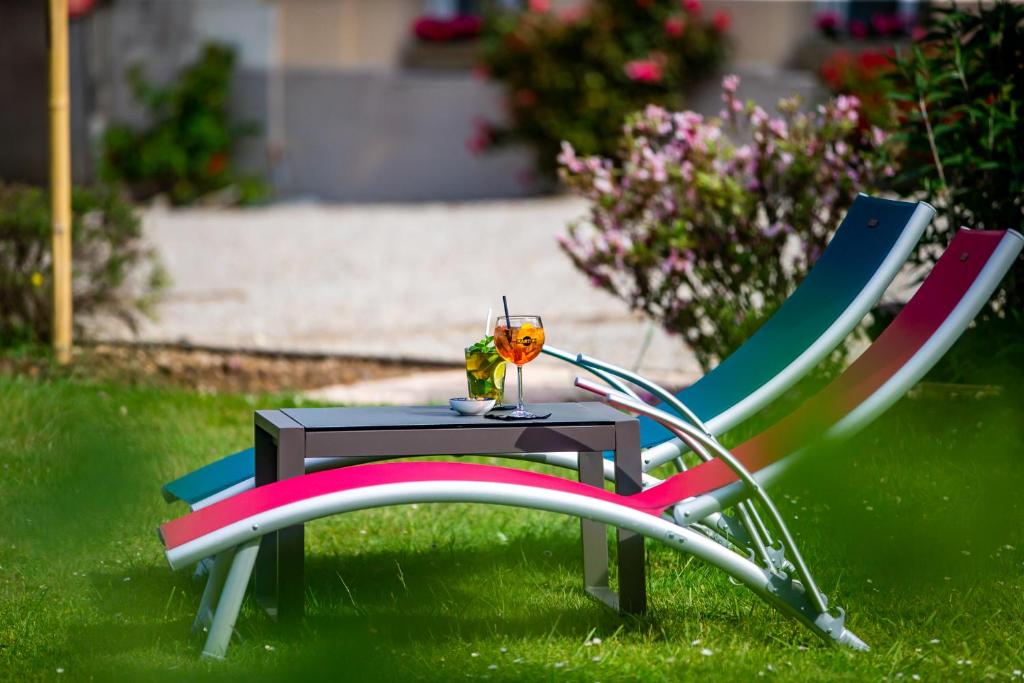 a chair and a table with a flower on it at La Villa Andry in Ouistreham