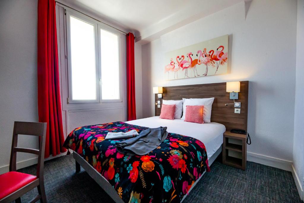 a bedroom with a bed and a window with red curtains at La Villa Andry in Ouistreham