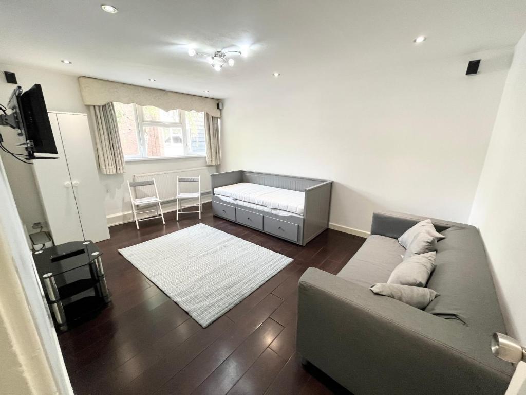 Large apt close to central LDN في لندن: غرفة معيشة مع أريكة وسرير