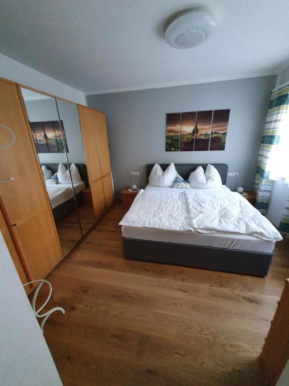 sypialnia z dużym łóżkiem i lustrem w obiekcie Ferienwohnungen Forever w mieście Gamlitz
