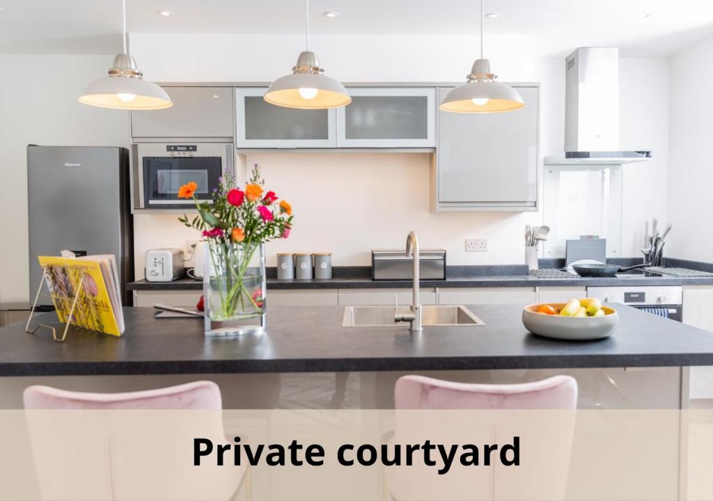 a kitchen with a counter with a vase of flowers at Elizabeth Flat 5 - By Luxury Apartments in Cheltenham