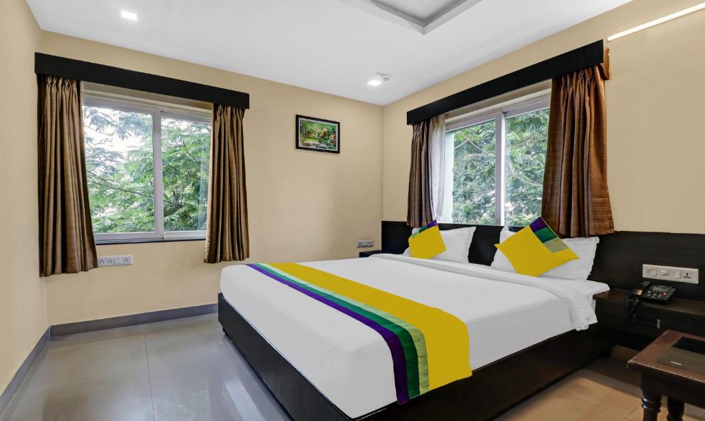 維沙卡帕特南的住宿－Itsy By Treebo - MVP Check Inn，一间卧室设有一张大床和两个窗户。