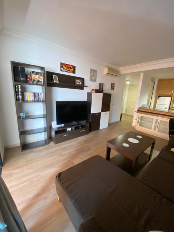 a living room with a couch and a tv at Vivienda Vacacional Krises in Puerto de Santiago