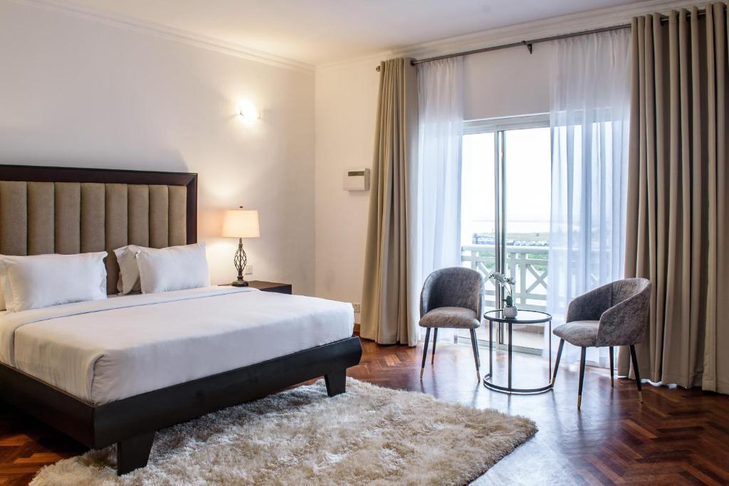 una camera d'albergo con un letto e un balcone di Pier Harbour Residences and Spa a Lagos