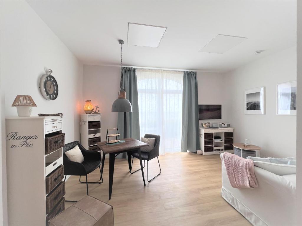 un soggiorno bianco con tavolo e sedie di Haus Alexandra - Ferienwohnung Dat Büdche a Wangerooge