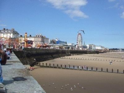 a bridge over a beach with people walking on the sand at Spa Holiday Apartments in Bridlington