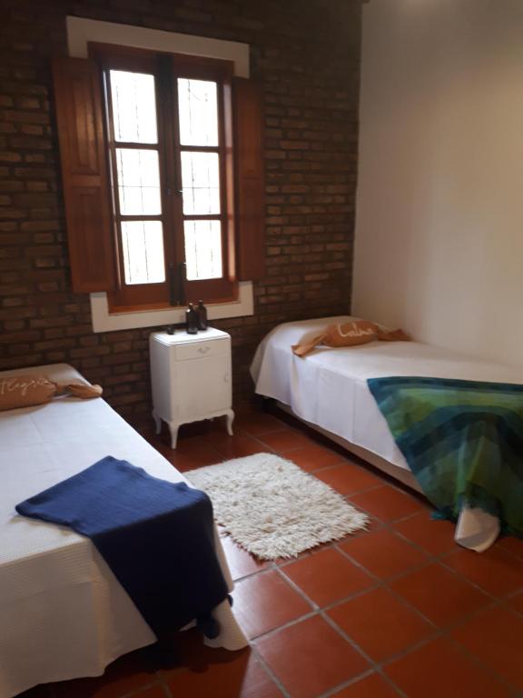 1 dormitorio con 2 camas y suelo de baldosa en Casa Paula en Las Rabonas
