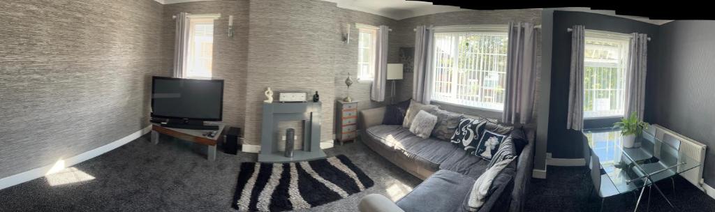 sala de estar con sofá y TV en Charlies, en Skegness