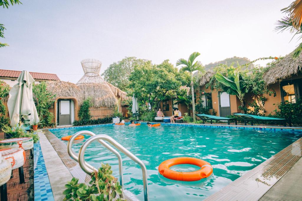 una piscina en un complejo con una balsa naranja en Tam Coc Sky Bungalow en Ninh Binh