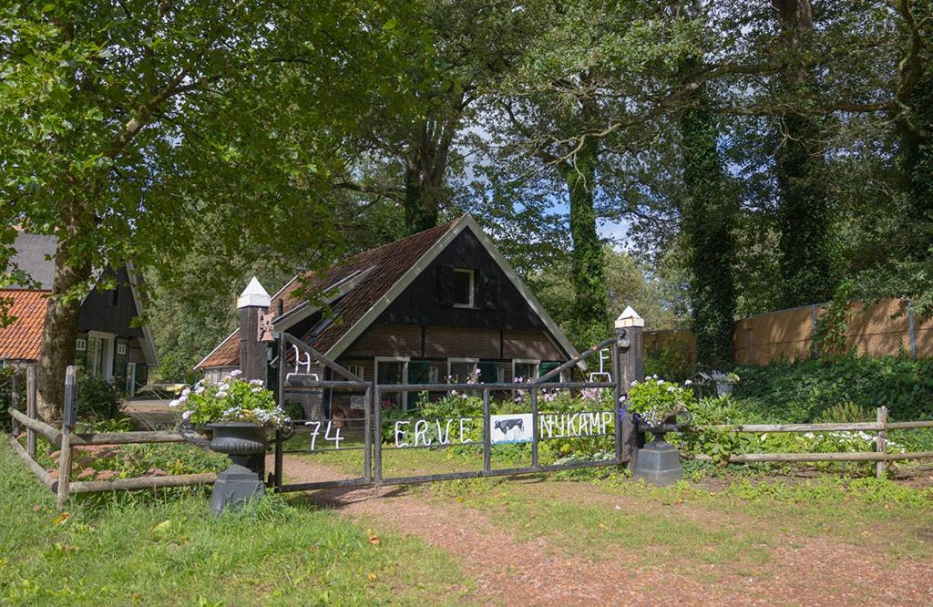 una pequeña casa con una valla delante de ella en Erve Nijkamp, en Tubbergen