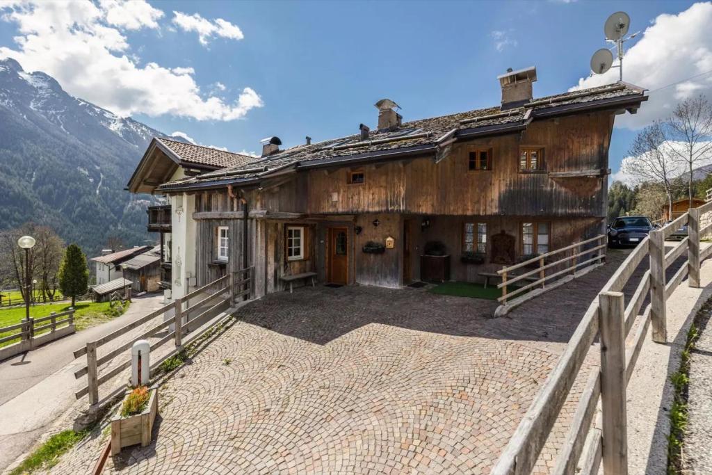 a large wooden house with a fence in front of it at Ciasa Sommavilla Calendula in Vigo di Fassa